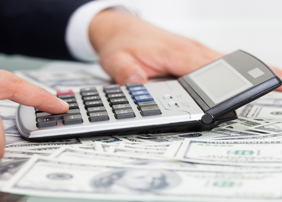 a calculator and dollars on a table