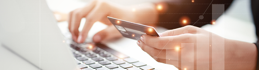  a person holding a credit card while typing on the laptop