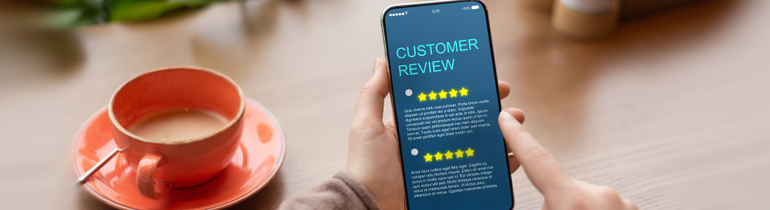 someone holding a cell phone. There are customer reviews on the screen