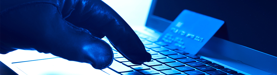 a credit card on top of a keyboard and someone wearing gloves