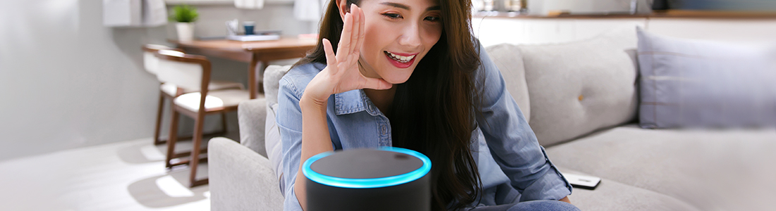 A woman talking into her smart speaker